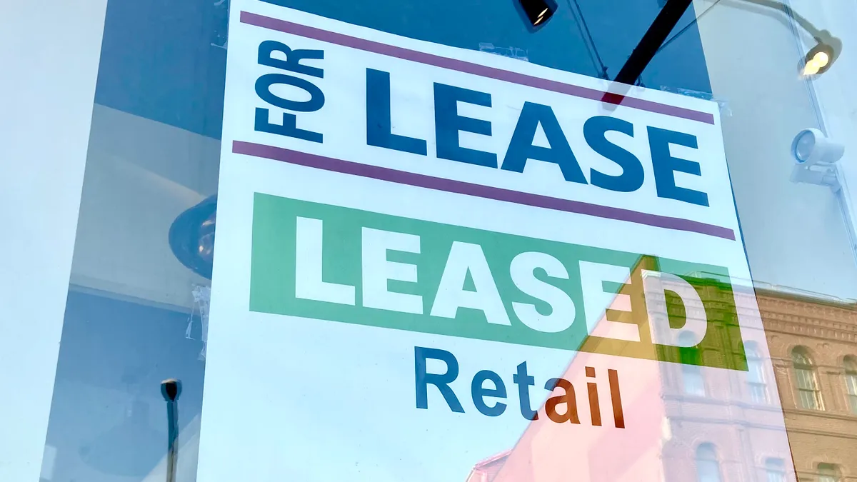 A "for lease" sign for retail space with a phone number.