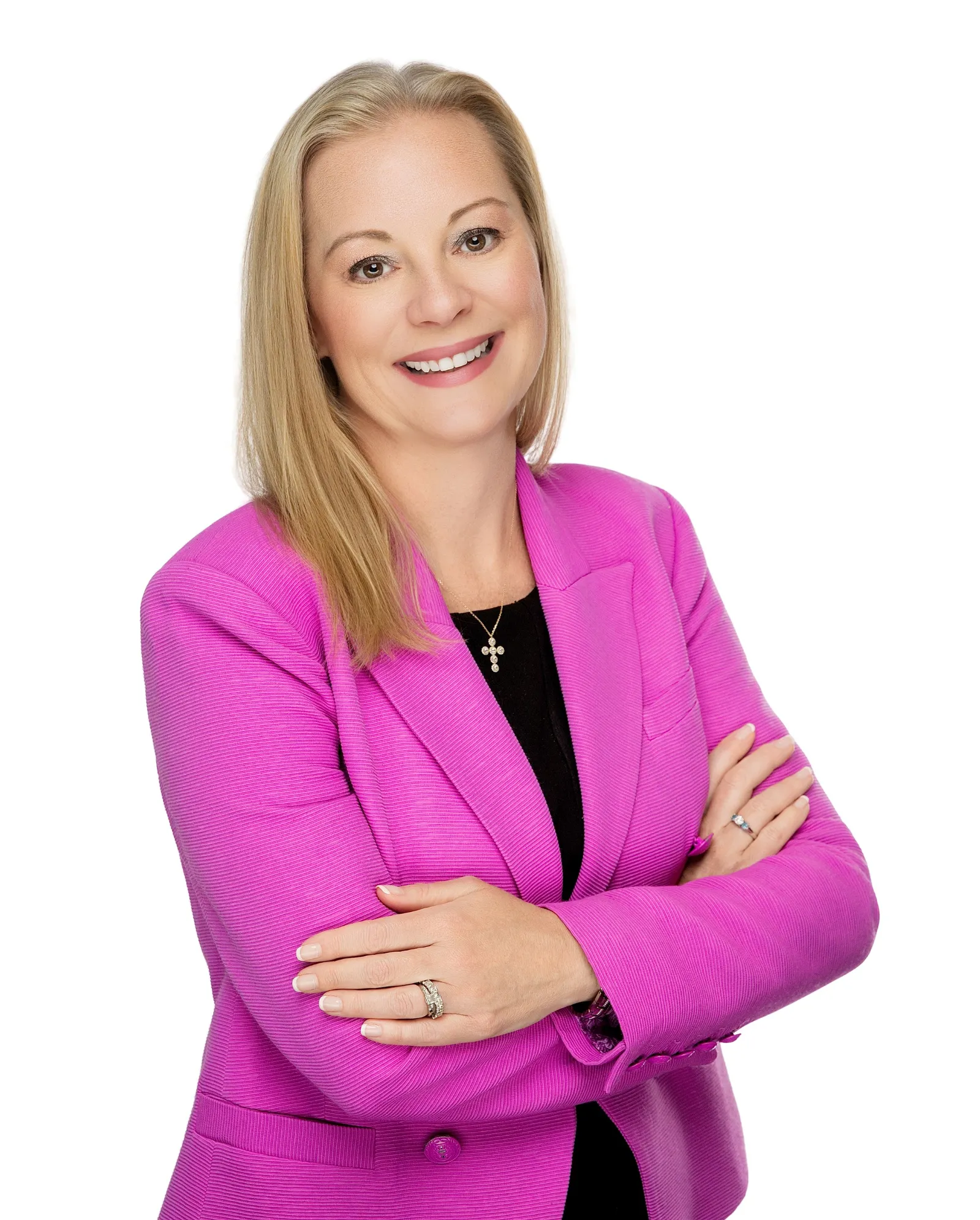 Hope Dmuchowski, wearing a pink blazer, crosses her arms and smiles for a photo