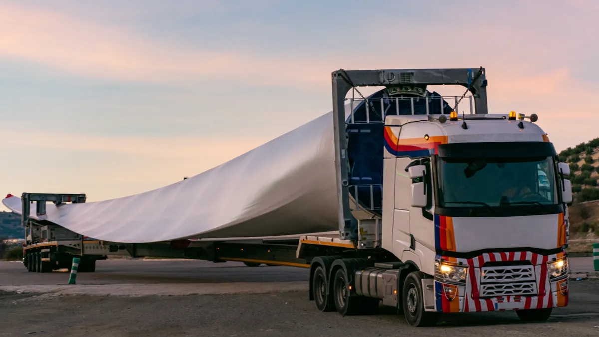 A truck carries a wind turbine.