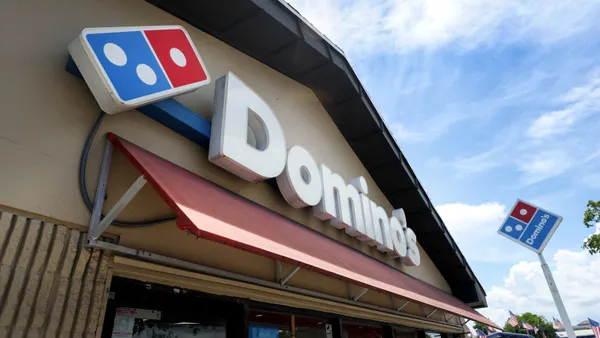 A daytime image of a Domino's restaurant and sign