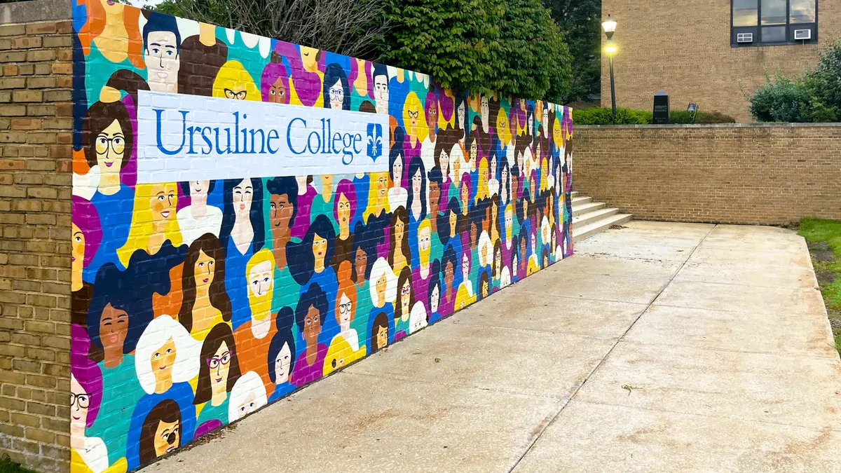 A mural reading "Ursuline College" surrounded by painted people.