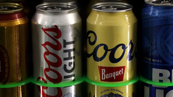 Two cans of Coors Light and Coors Banquet in a convenience store cooler.