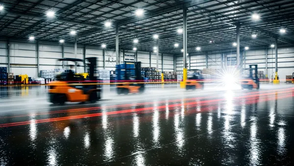 Forklifts moving around in a warehouse