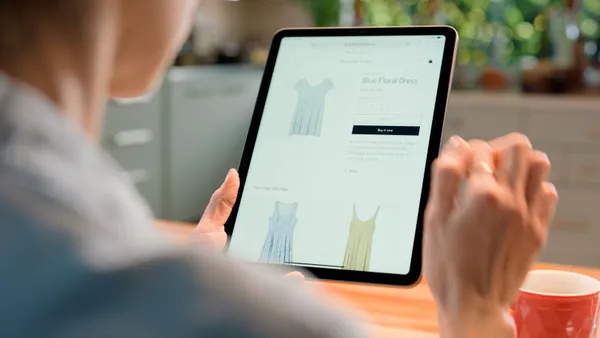 A person shops for clothing on a tablet.