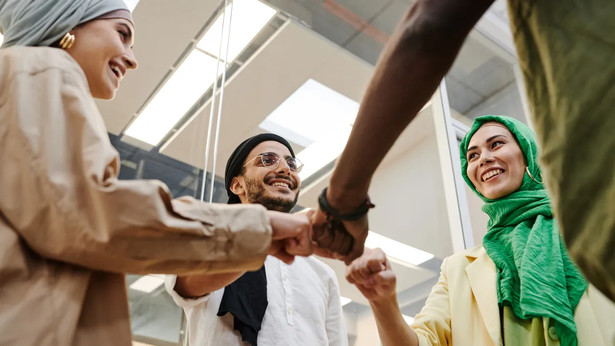 A group of employees do fist-bumps in the office