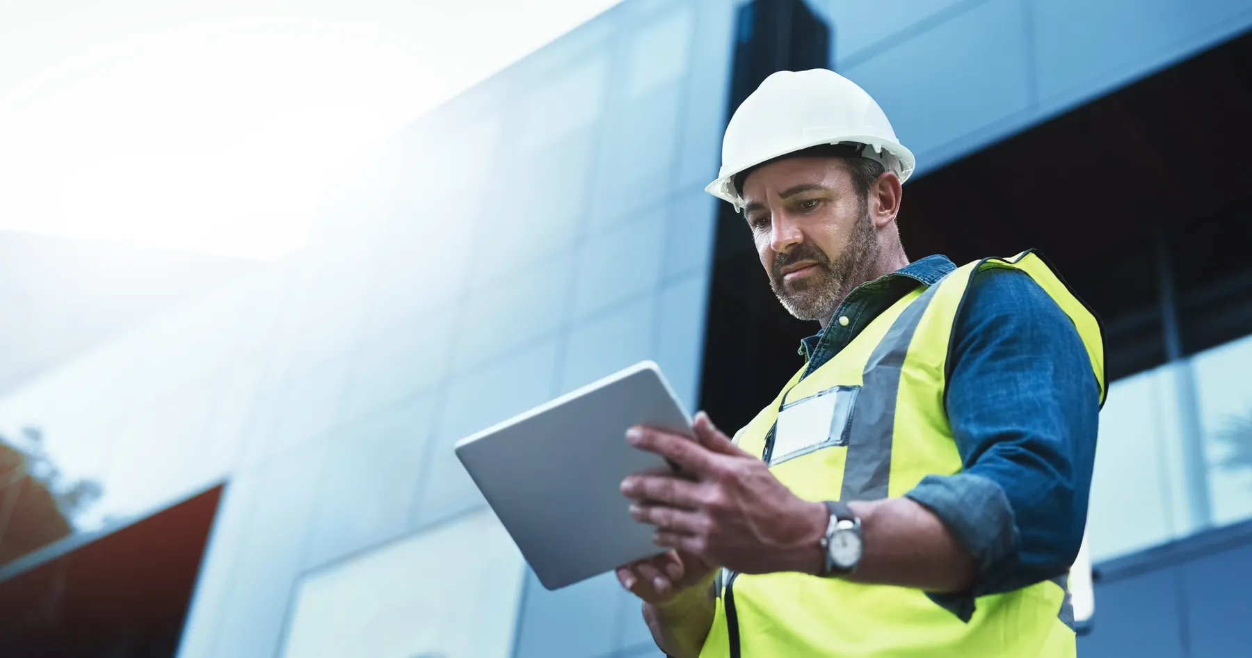 A shot of a building worker using a digital tablet at a construction site.