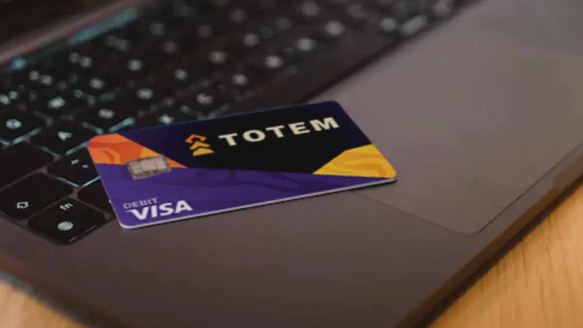 A Totem debit card lies on a laptop computer