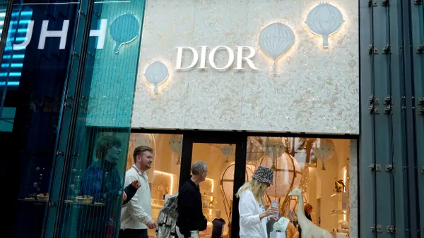 People walk by a Dior storefront.