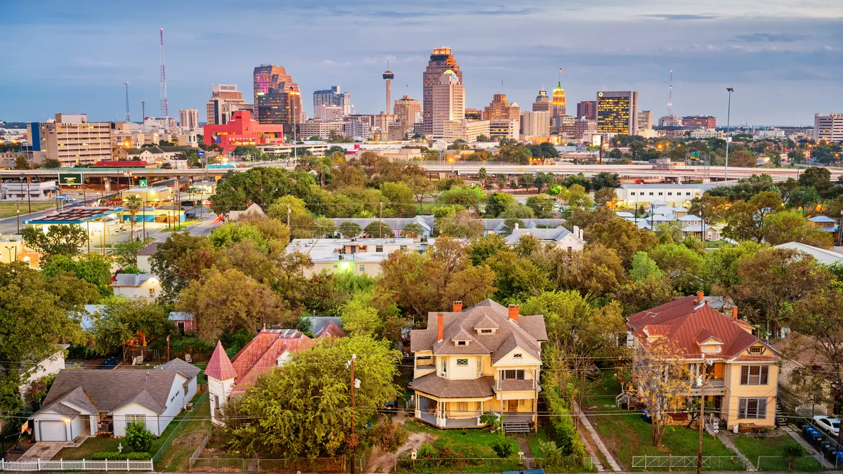 City skyline behind trees and homes.