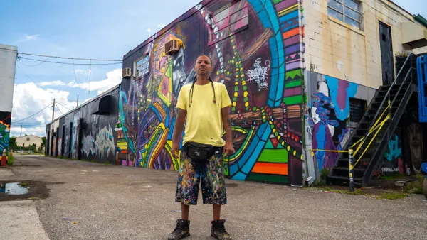 Artist Don Rimx poses in front of mural art in Vitaminwater's new content series.