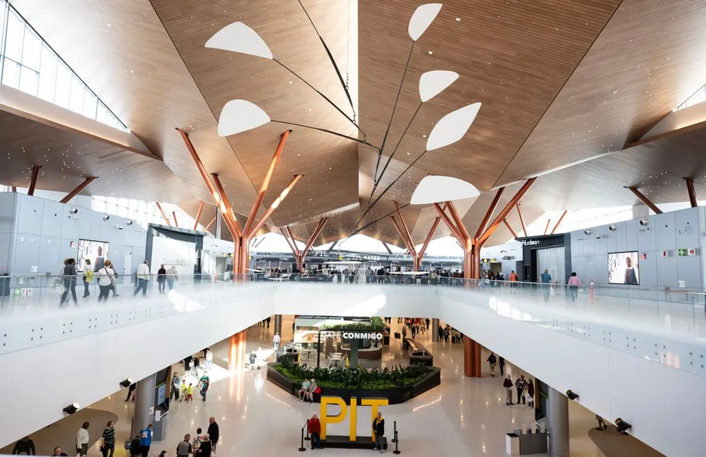 A photo shows passengers walking through the upper and lower levels of an airport terminal.