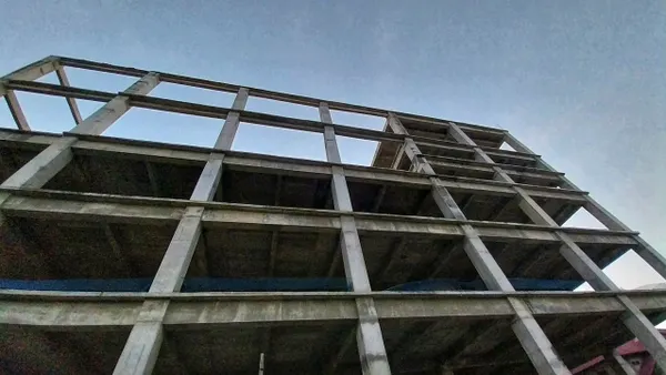 An abandoned apartment construction project, a massive building that remains incomplete and only displays empty box-shaped frames on each floor.