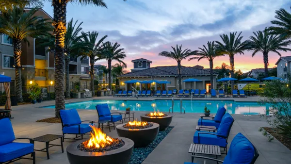 Pool surrounded by apartment building and palm trees