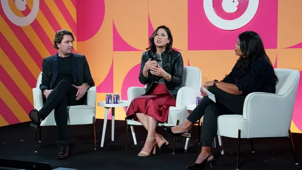 Executive sit on a stage in white chairs during an Advertising Week New York 2025 panel. From left: Diederik Koenders, vice president of consumer engagement at MAC Cosmetics; Laurie Lam, chief brand officer at E.l.f. Beauty; and Asha Shivaji, CEO and co-founder of SeeMe Index.