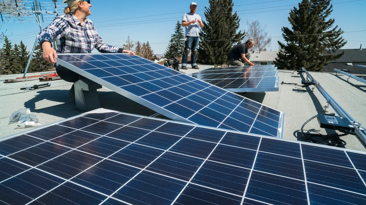 Workers installing solar panels on a residential homes roof.