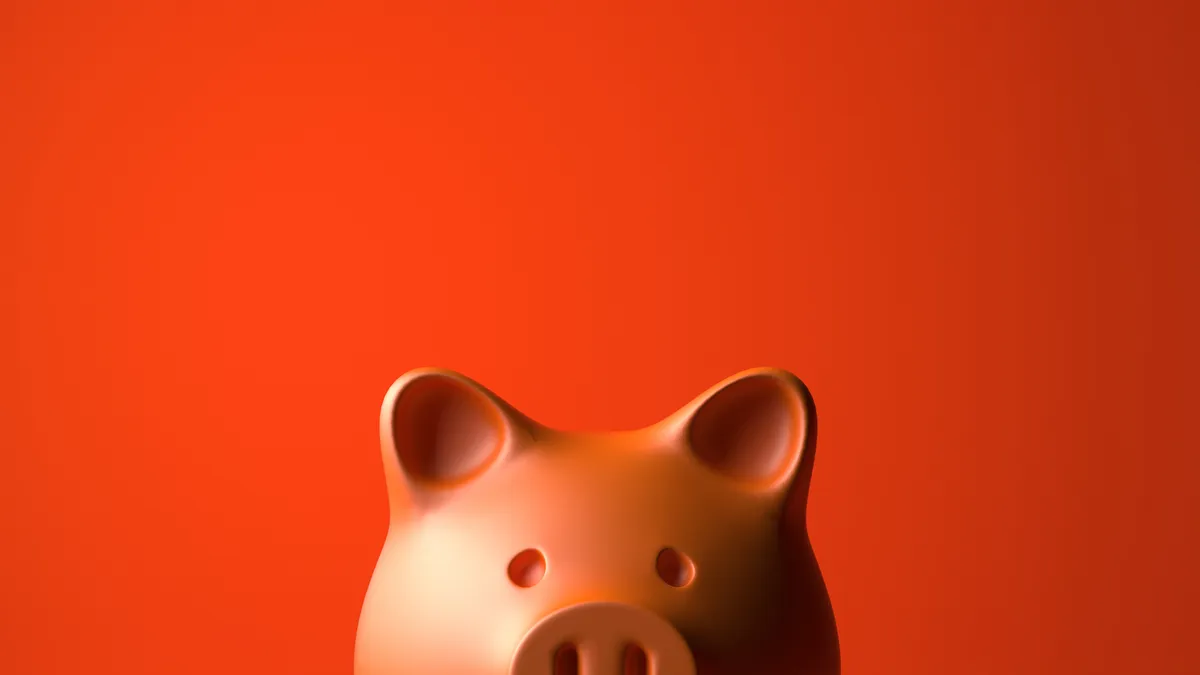 Close up portrait of piggybank looking at camera over red background