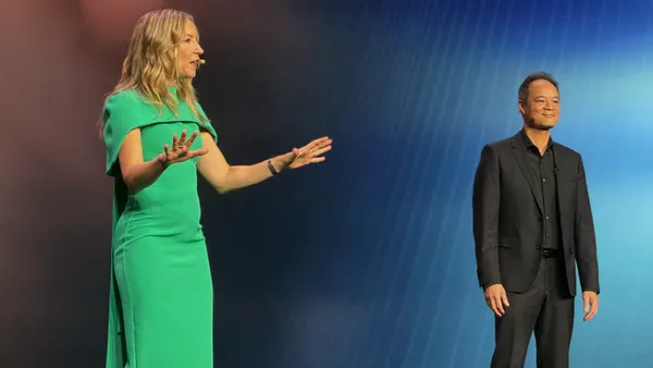 Two analysts on a conference stage during a keynote speech