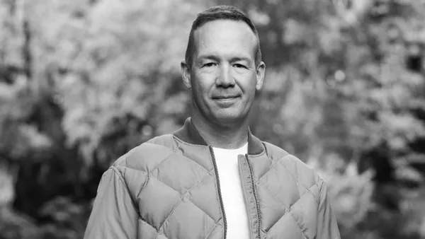 Tim Bantle stands outdoors for a professional headshot in black and white.