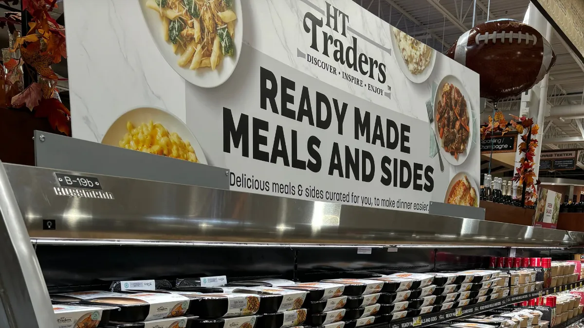 A sign above food in a grocery store.