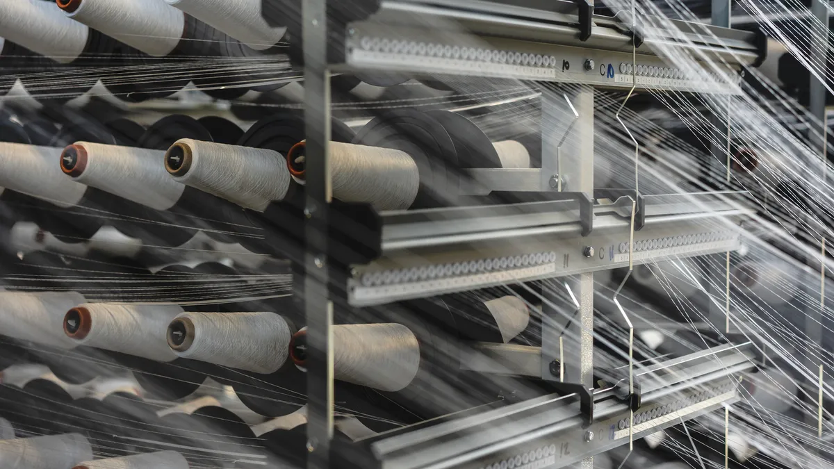 Spools of thread are seen going through the Vega machine.