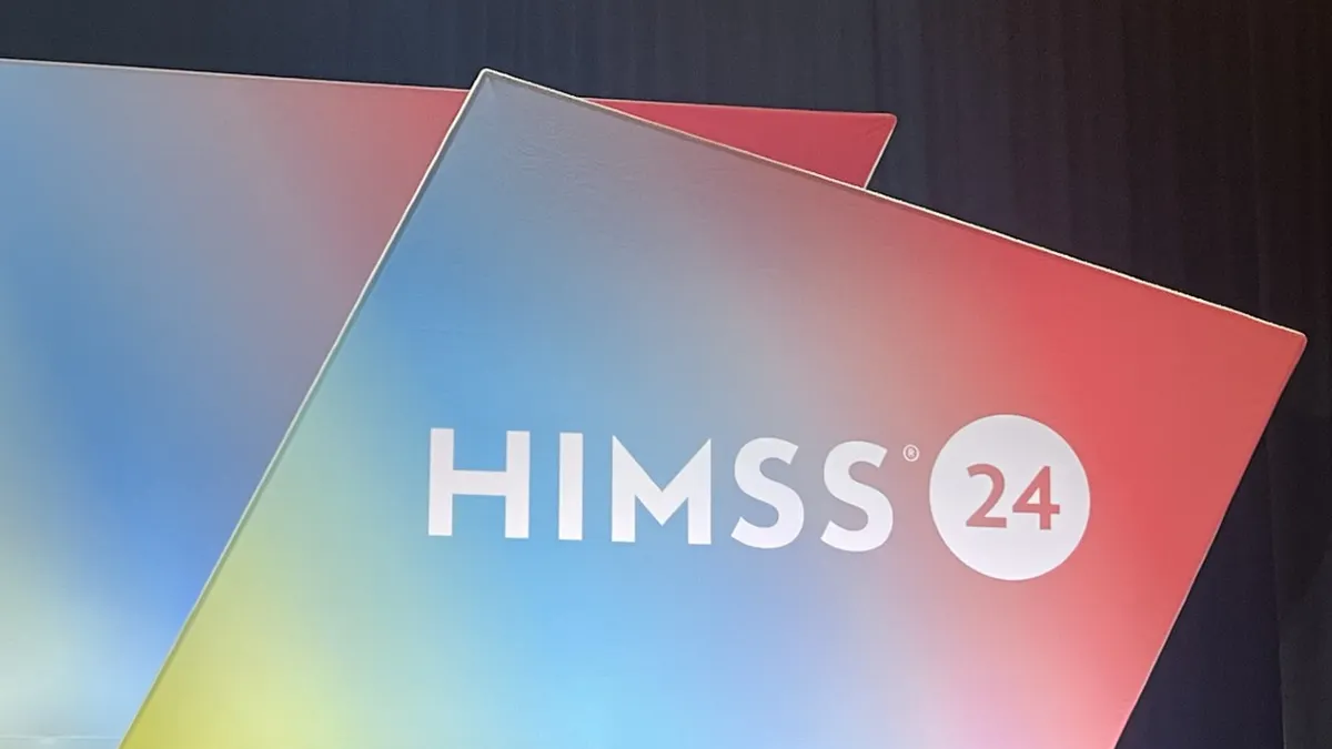 The HIMSS logo is seen on a multicolored backdrop onstage.