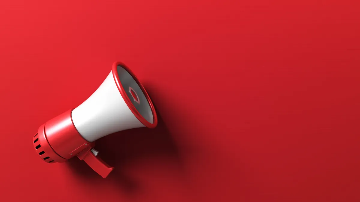 A red and white megaphone lays against a red background.