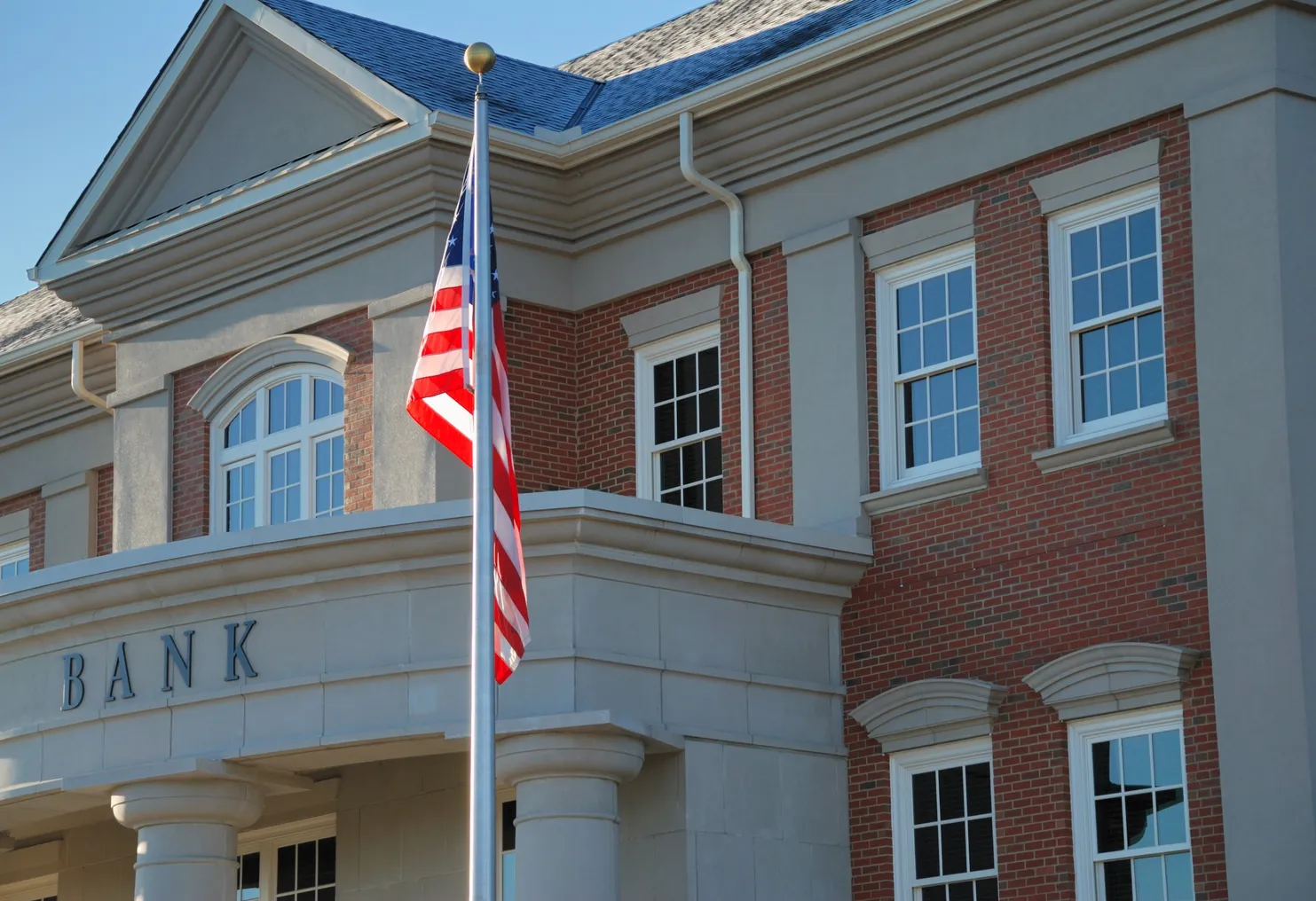 American bank building is pictured with an American flag flag on cold morning.