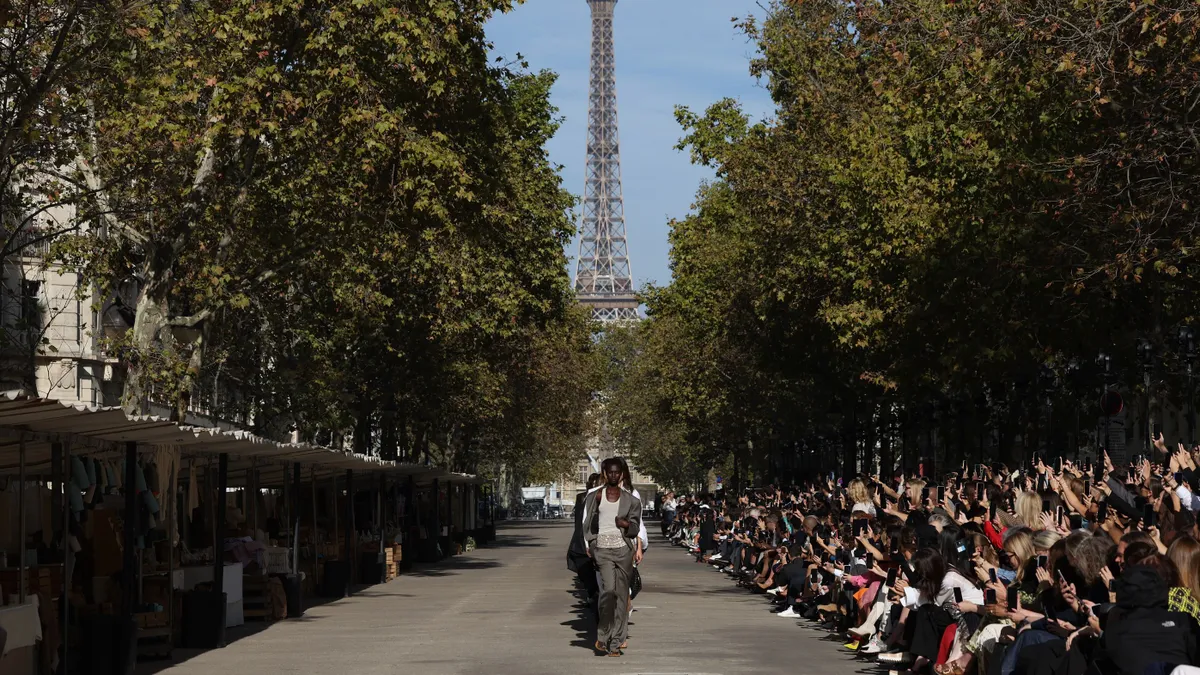 Models walk a wide outdoor runway in Paris with the Eiffel Tower in the background during the Stella McCartney Womenswear spring-summer 2024.