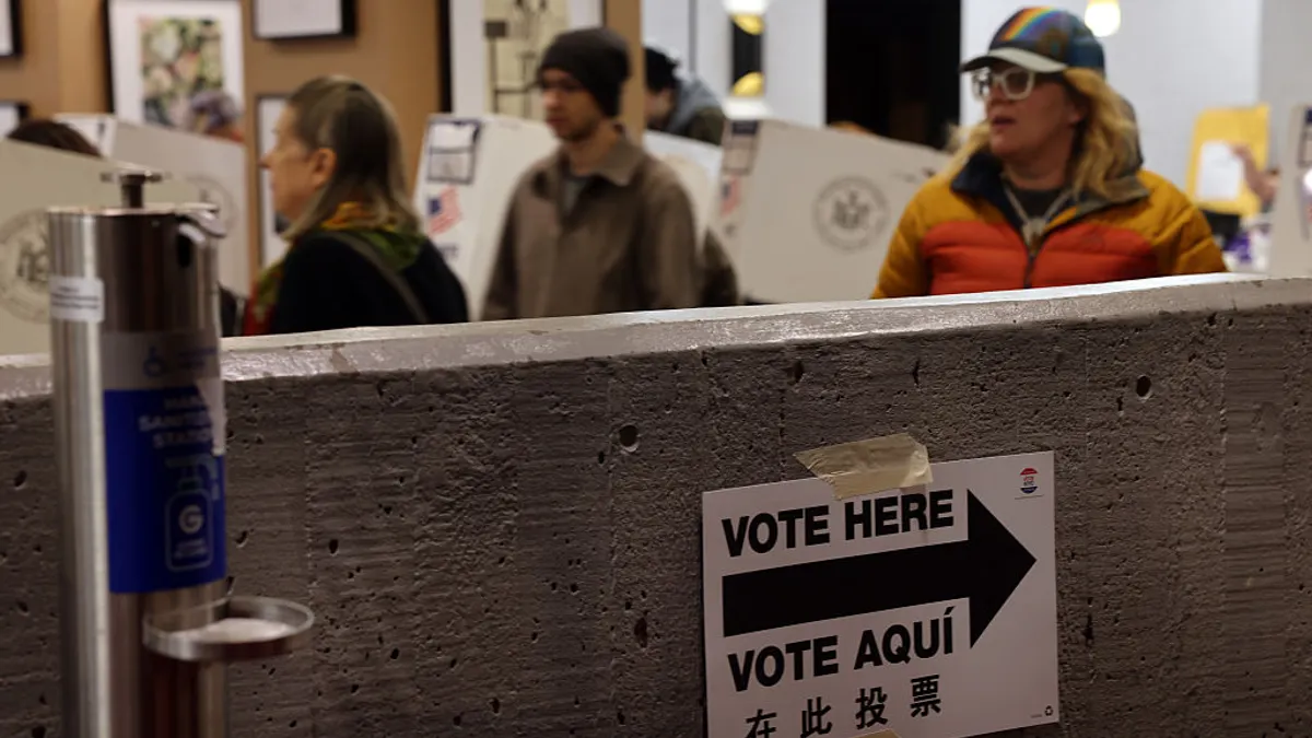 Voters stand near polling machines.