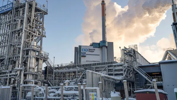 A large industrial facility with smokestacks and snow on the campus.