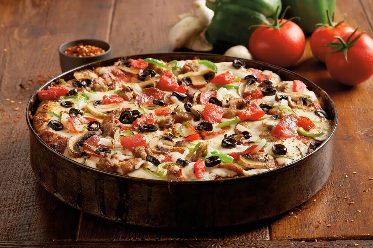 A close up image of a deep dish pizza with several toppings.