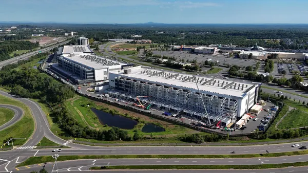 An aerial view of the construction of a large data center under construction next to a highway