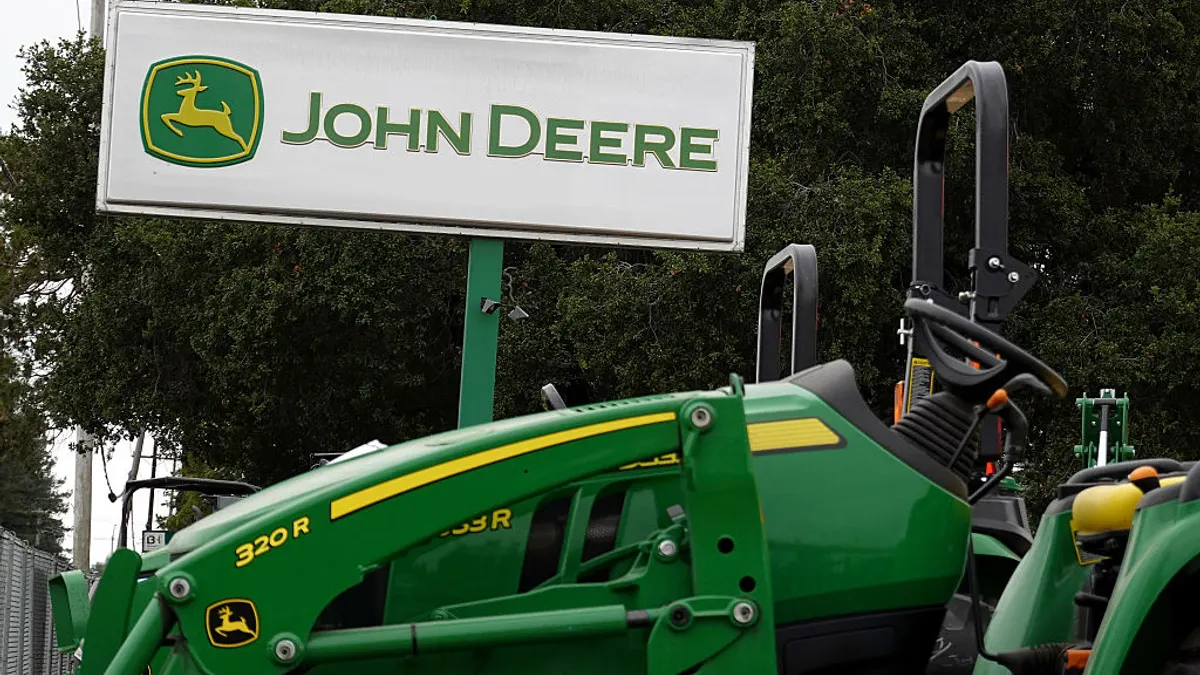 A sign posted in front of a Deere & Co. dealership