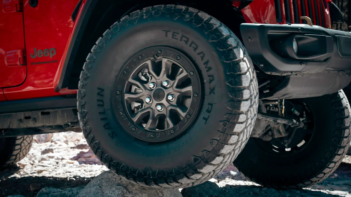 A tire of a red Jeep in motion.