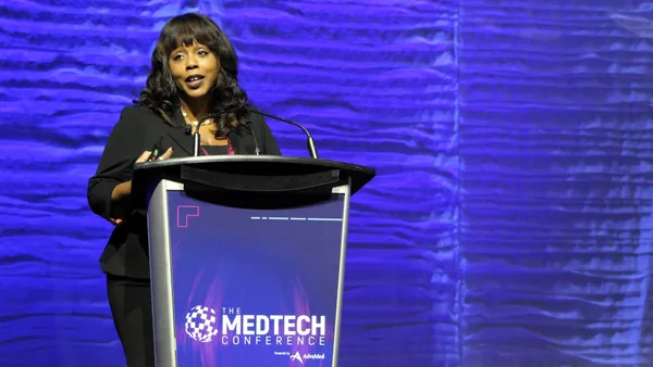 A person speaks at a podium on a stage.