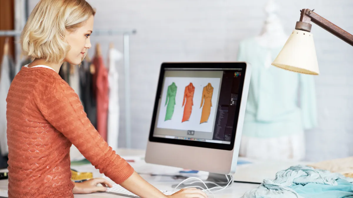 A beautiful young fashion designer working on her computer