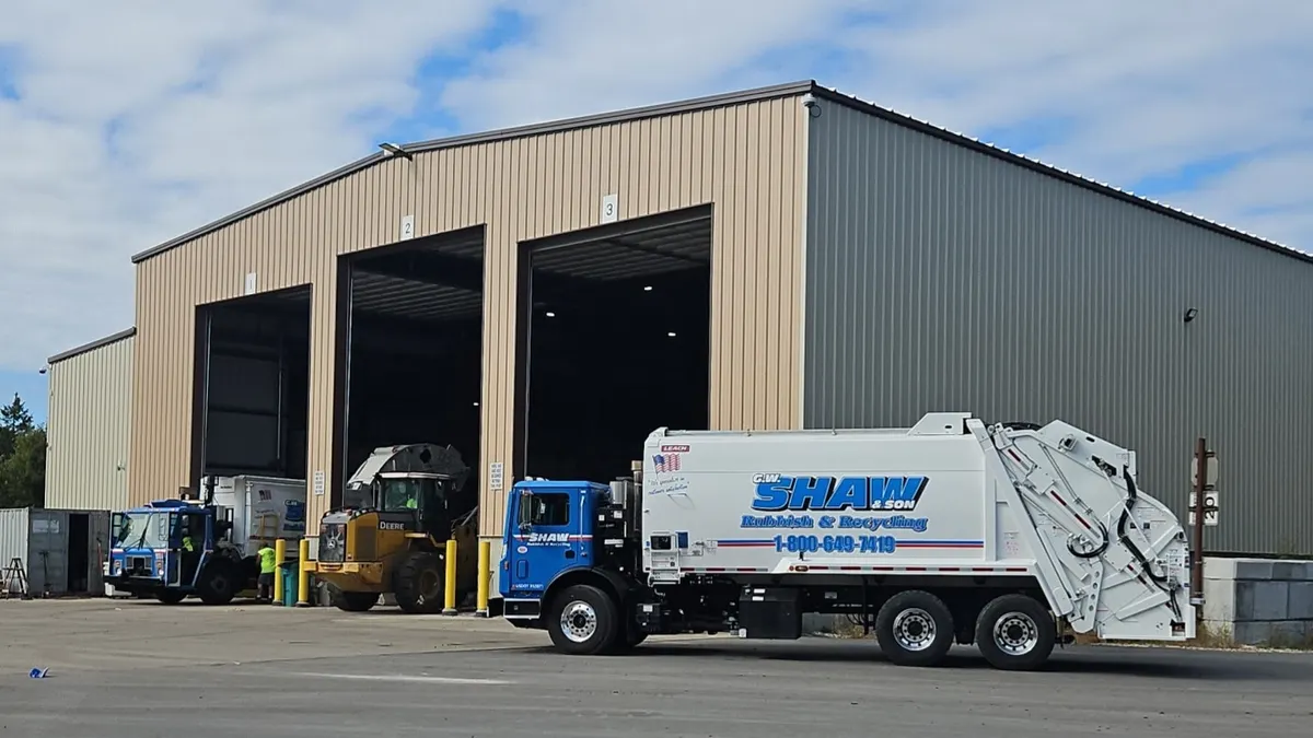 A truck with the logo "G.W. Shaw & Son Rubbish & Recycling" sits in front of an industrial building in Greenville, New Hampshire