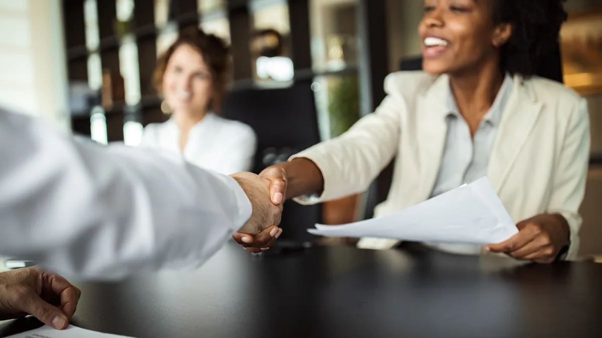 Business woman making plans with somebody, shaking hands.