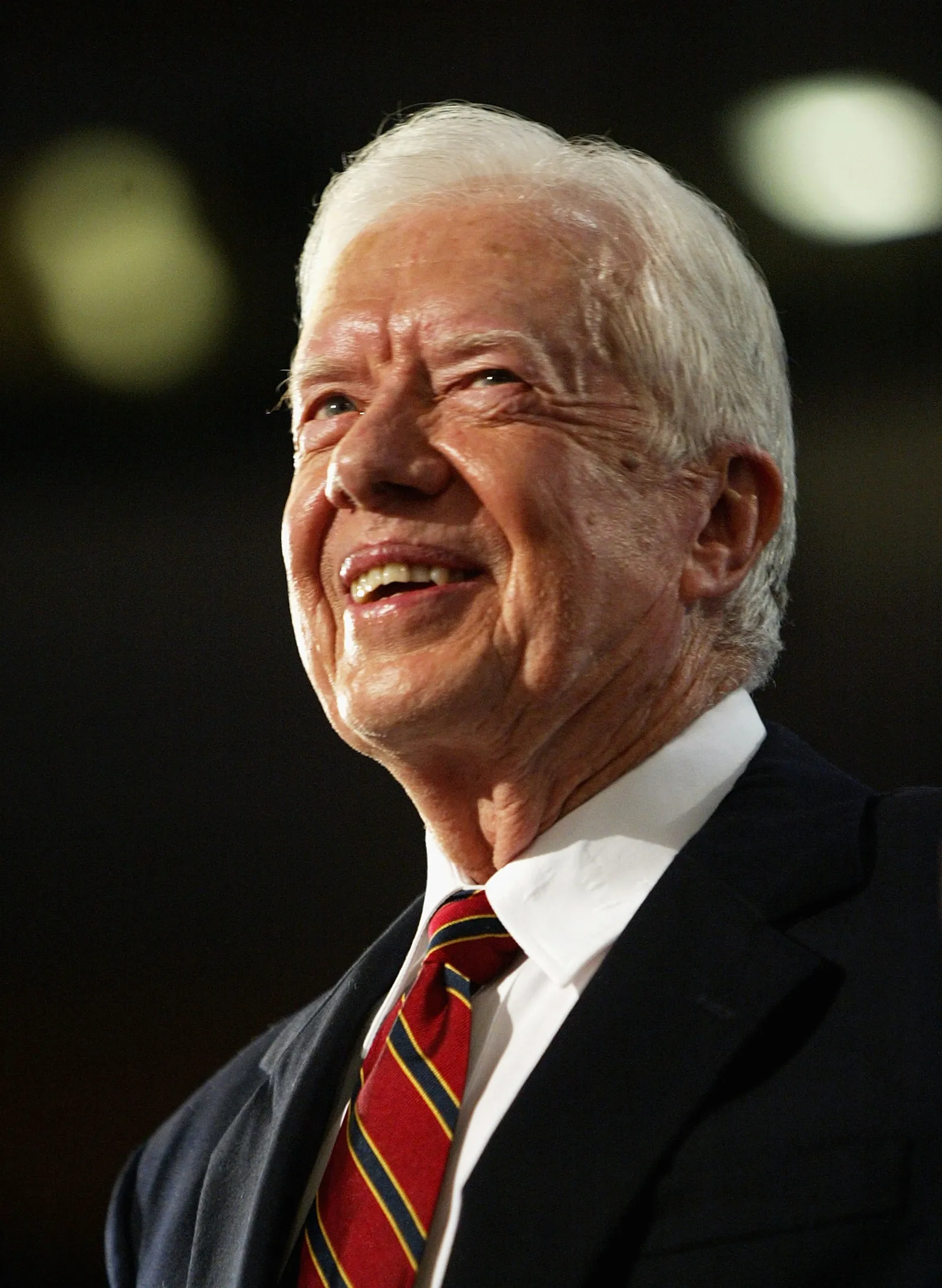 A close up headshot of former President Jimmy Carter standing on stage.