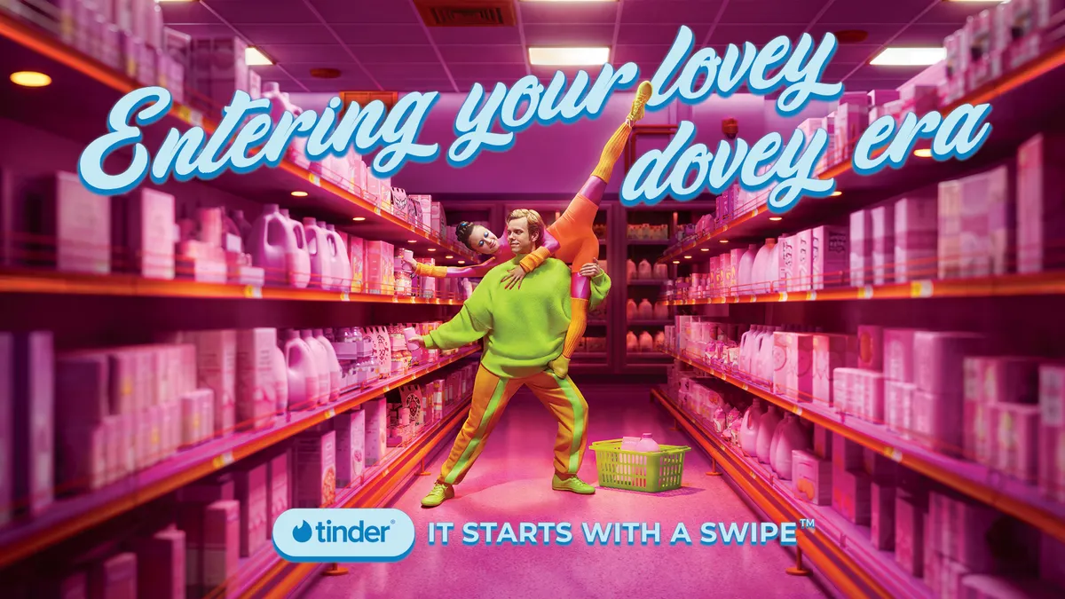 Imagery for Tinder's expanded "It Starts with a Swipe" global brand platform ahead of Dating Sunday shows a couple dancing together in the aisle of a grocery store.