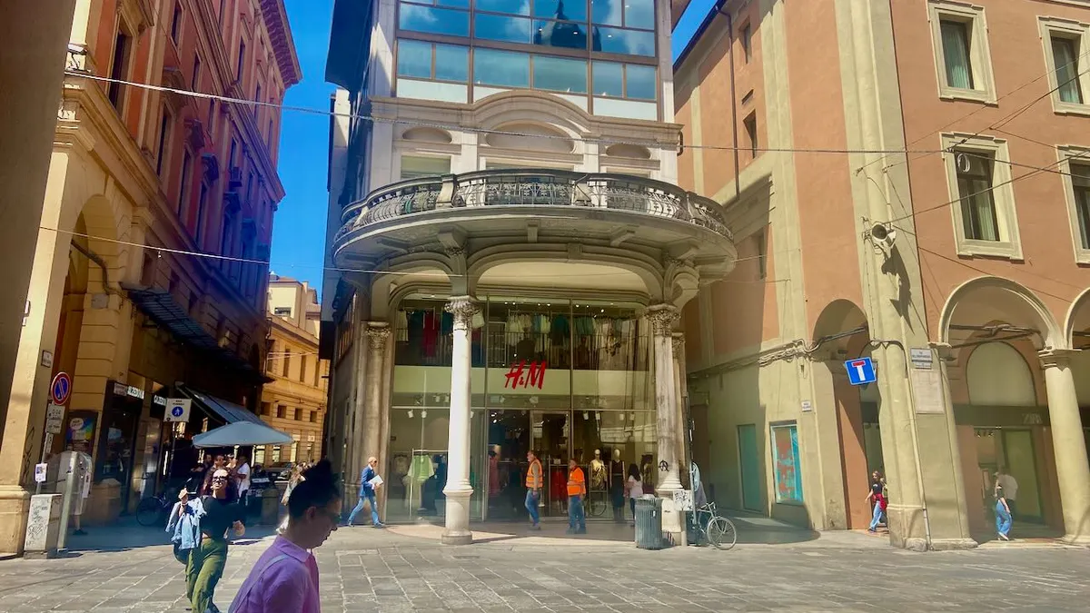 People milling around an H&M store on a sunny day.