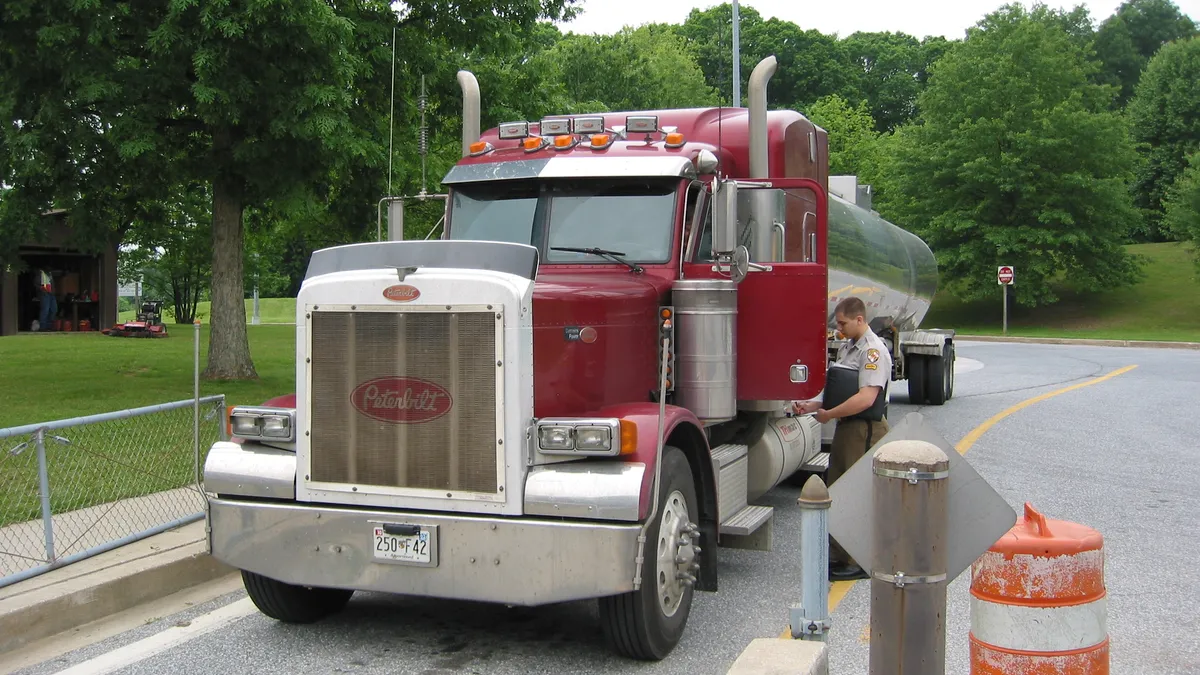 A highway official inspects a tanker during an annual road check. (Year and location unknown.)