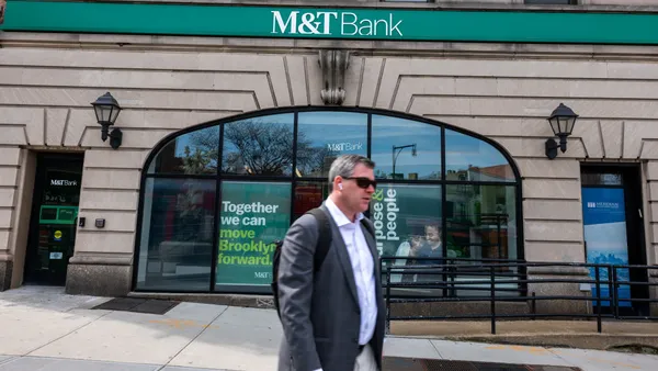 A bespeckled man walks in front of M7T Bank in Brooklyn, NY.