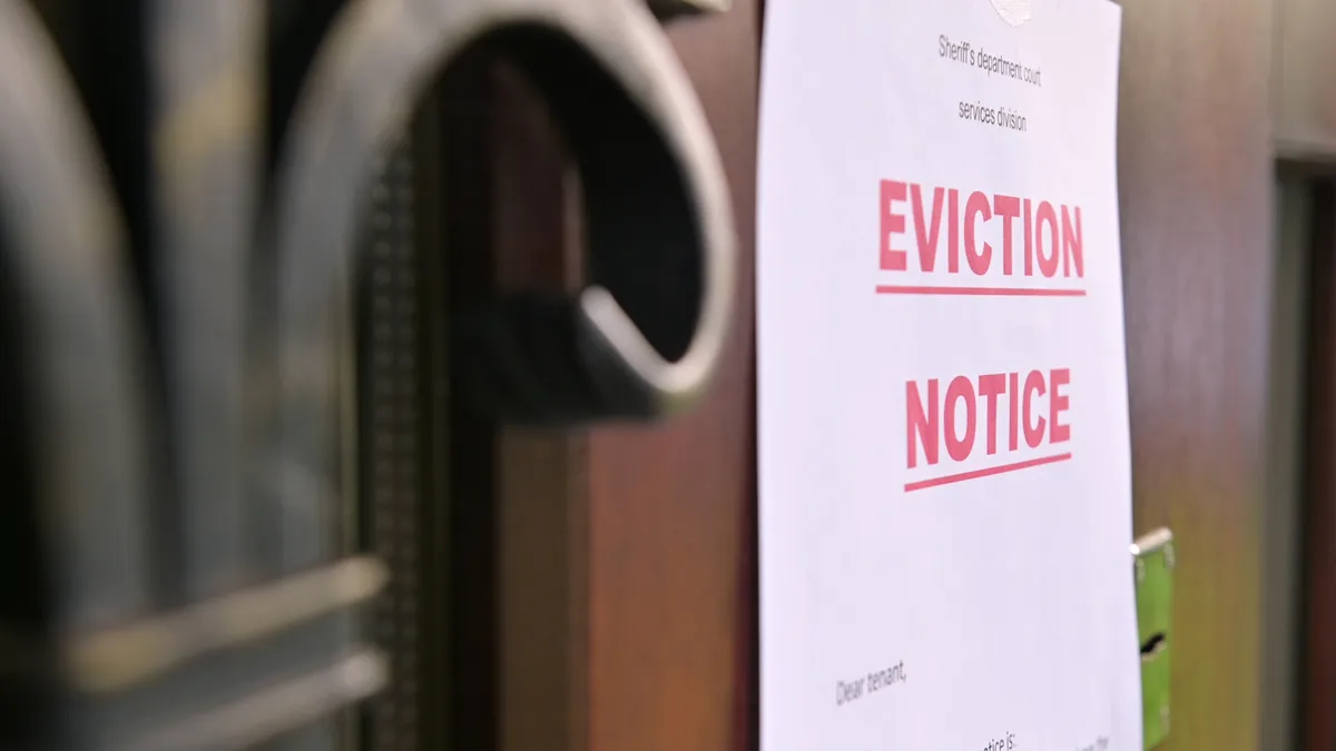 the notice of eviction of tenants hangs on the door of the house, front view