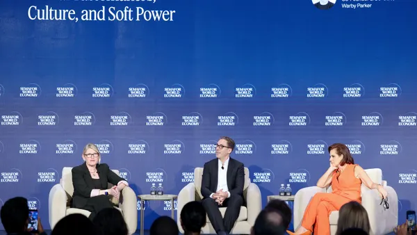 Three people talk on a panel.