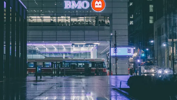 BMO's logo in the dark next to public transit and vehicle lights.