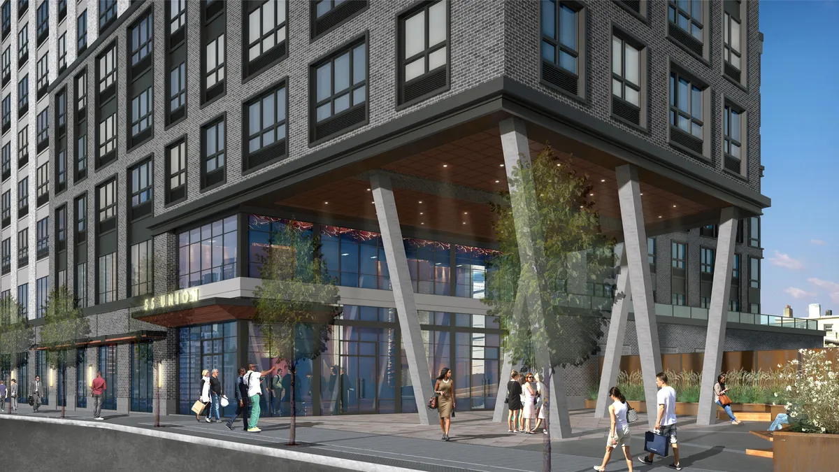 An apartment building with a front plaza that pedestrians are walking through.