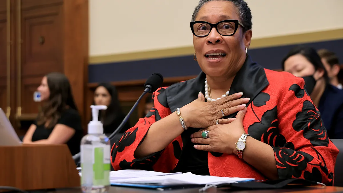 Woman in red shirt speaking before Congress.