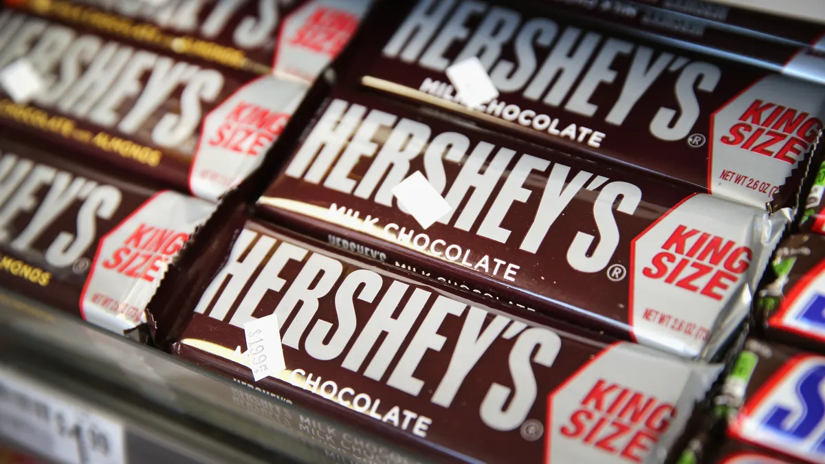 A row of king-sized Hershey chocolate bars sit on the shelf in a store.