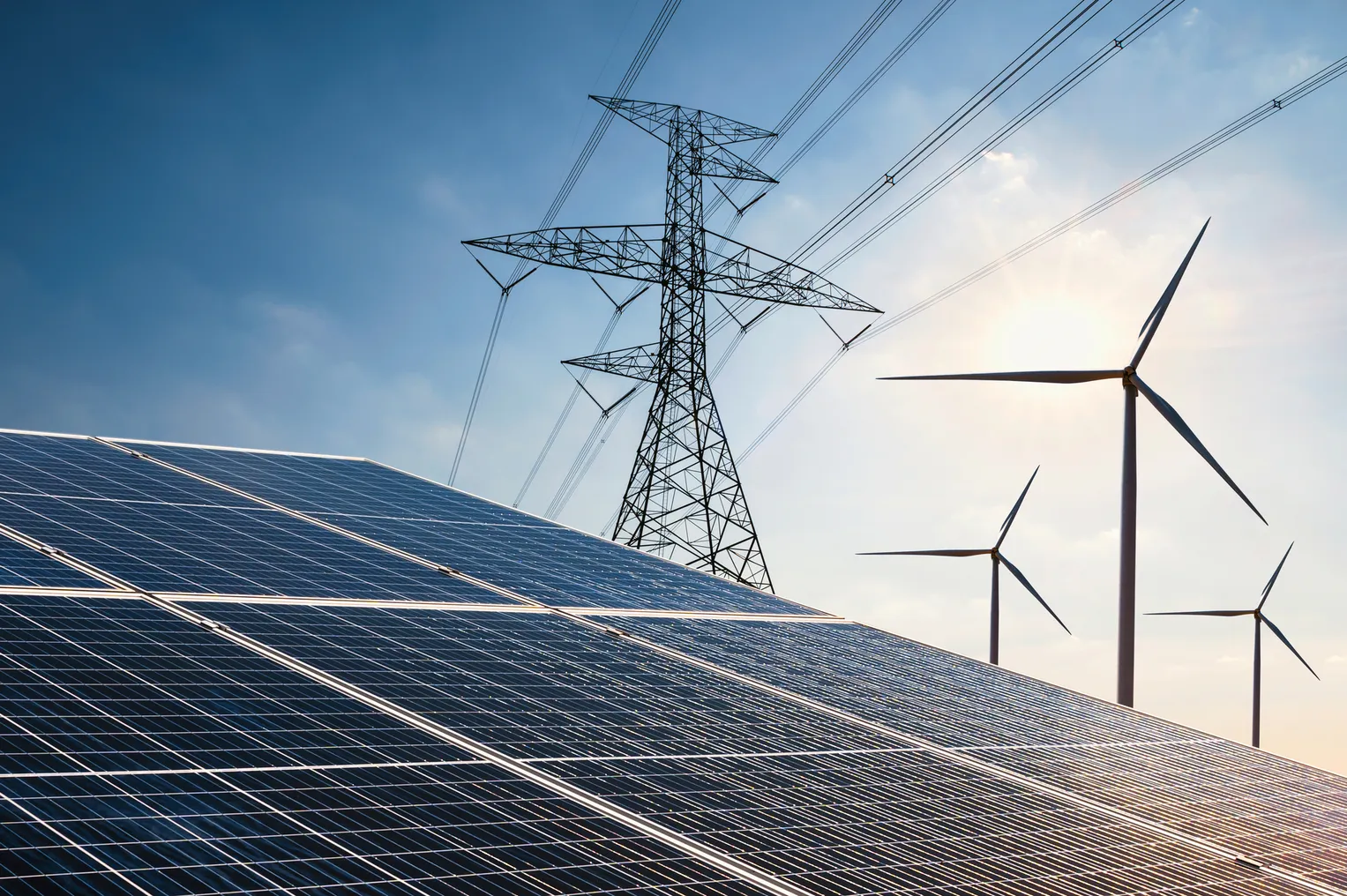 Solar panels, wind turbines and a transmission line.